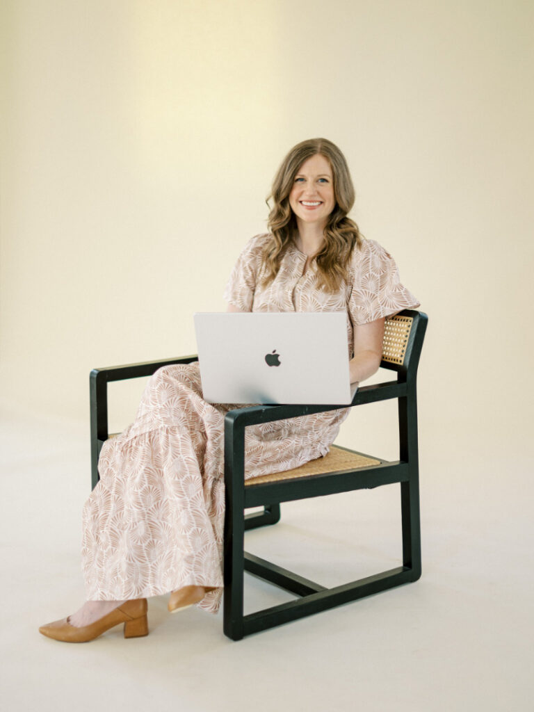 Designer seated with laptop, example of best wedding photographer websites inspiration and branding clarity.