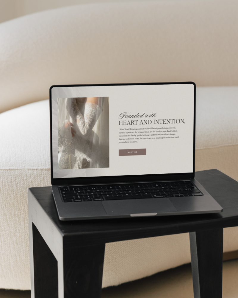 Modern wedding website homepage displayed on a laptop in a neutral-toned workspace